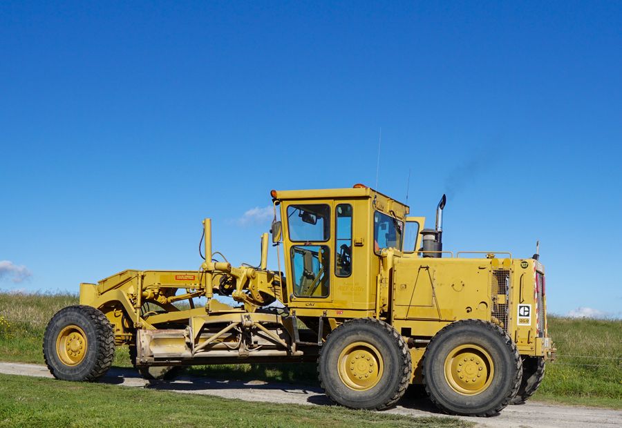 Motor grader shaping the surface of a gravel country lane
